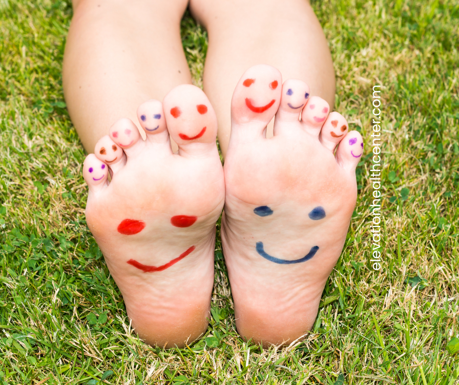 Feet with painted on smiley faces to show help for burning sensation in feet